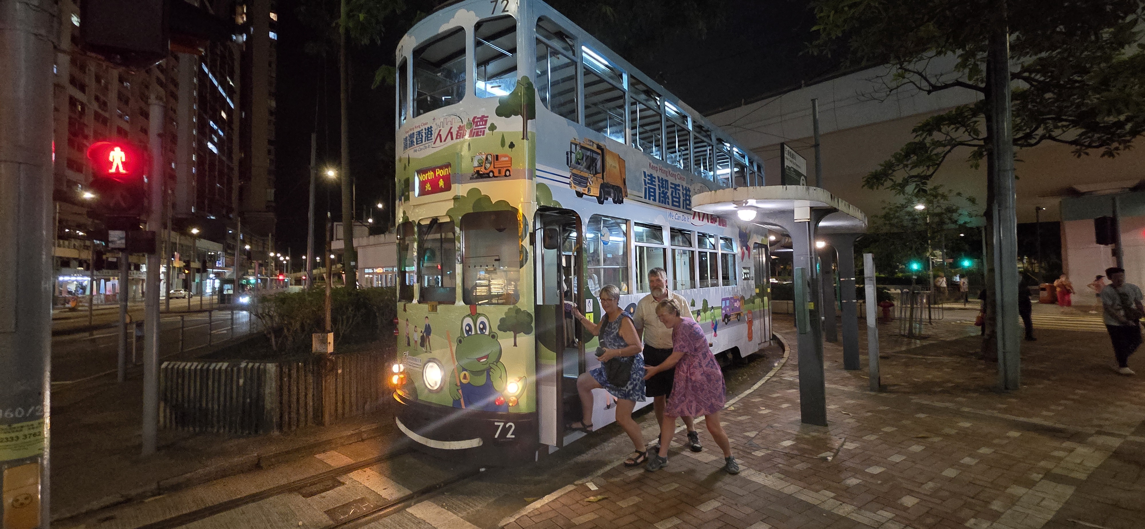 Karen and friends boarding a Hong Kong tram at night